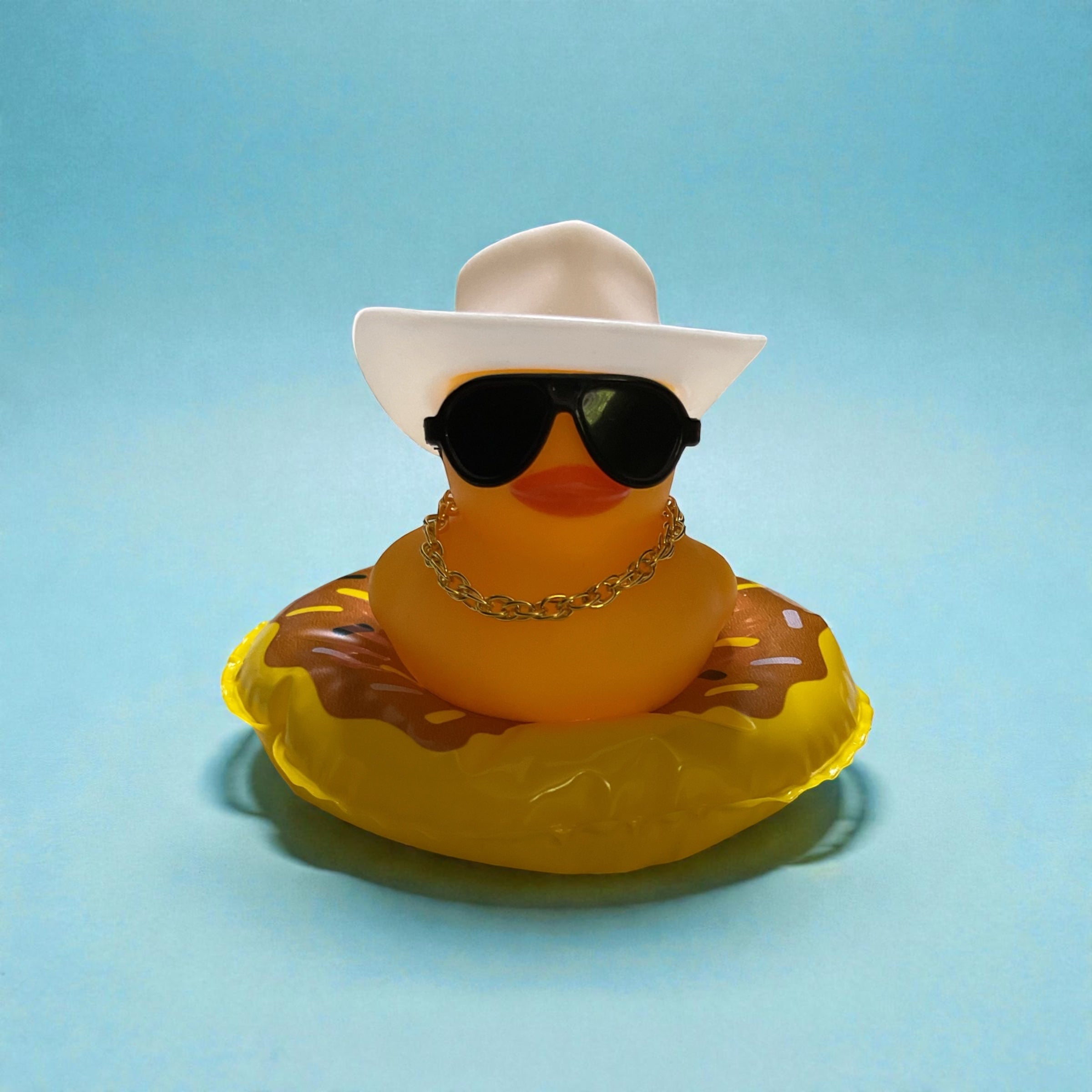 Yellow Duck with White Cowboy Hat, Black Sunglasses, Gold Necklace sitting on a Donut Tube