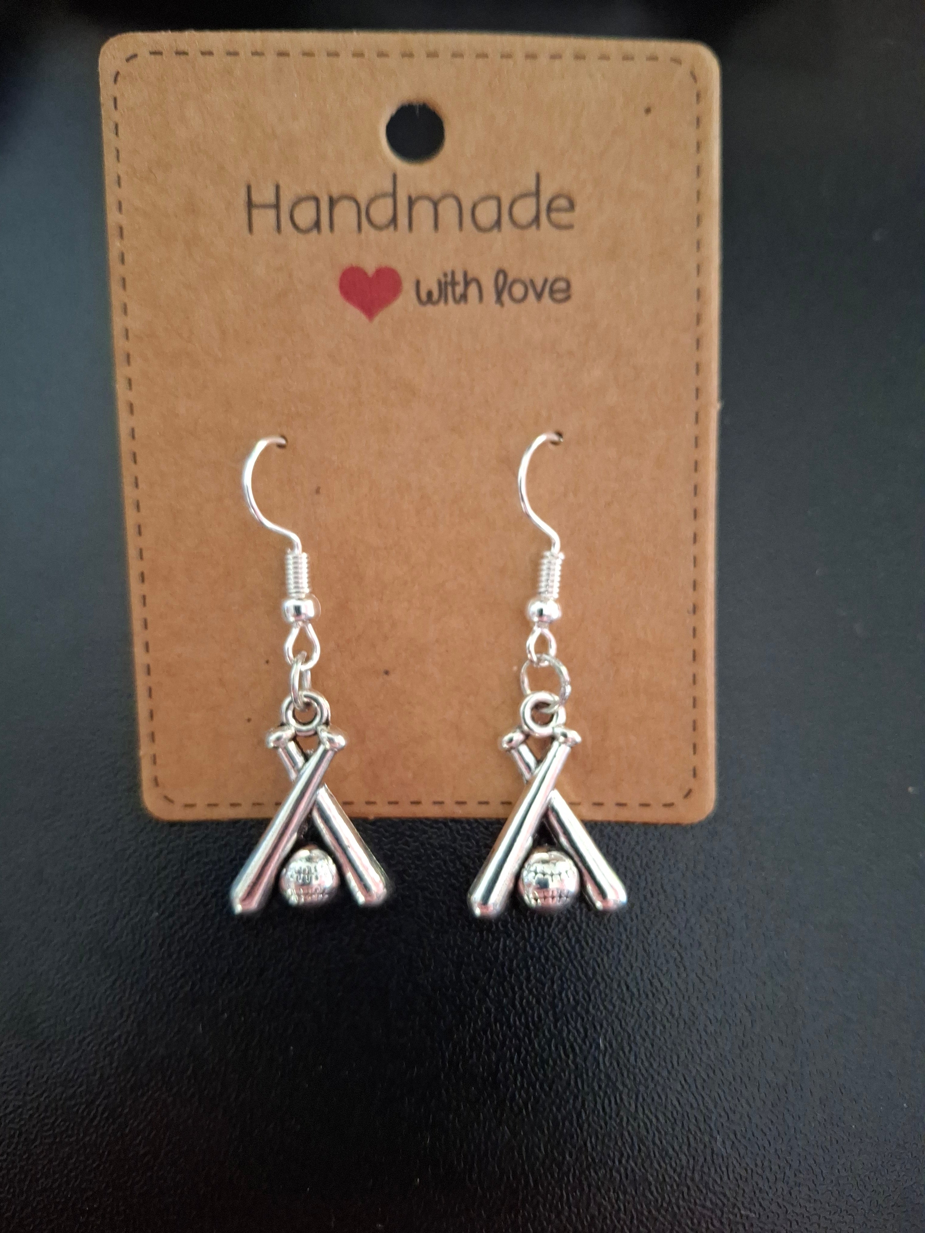 Silver bow-shaped earrings on a 'Handmade with Love' card against a dark background