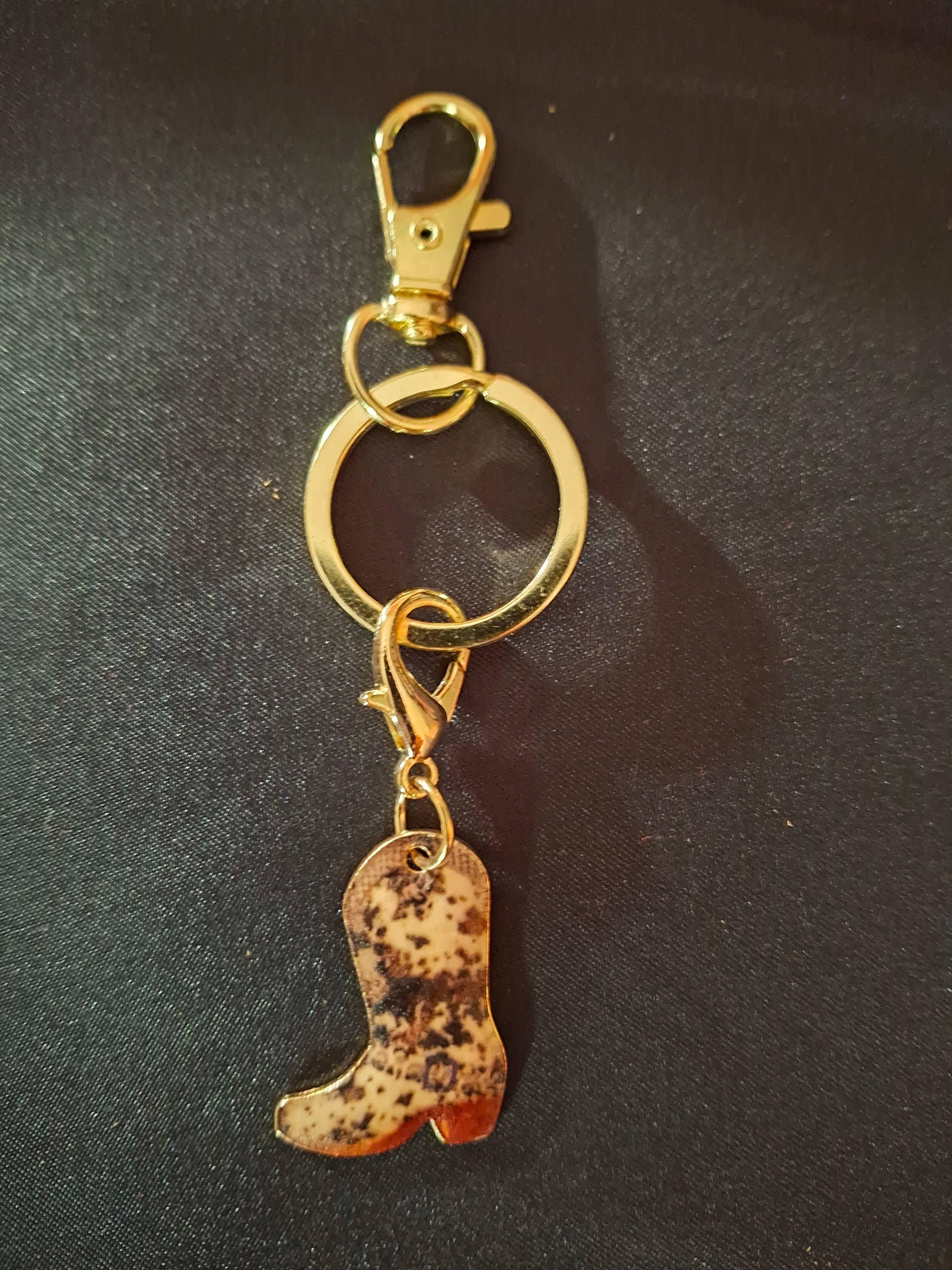 Keychain with gold ring and dog bone-shaped charm on a dark background