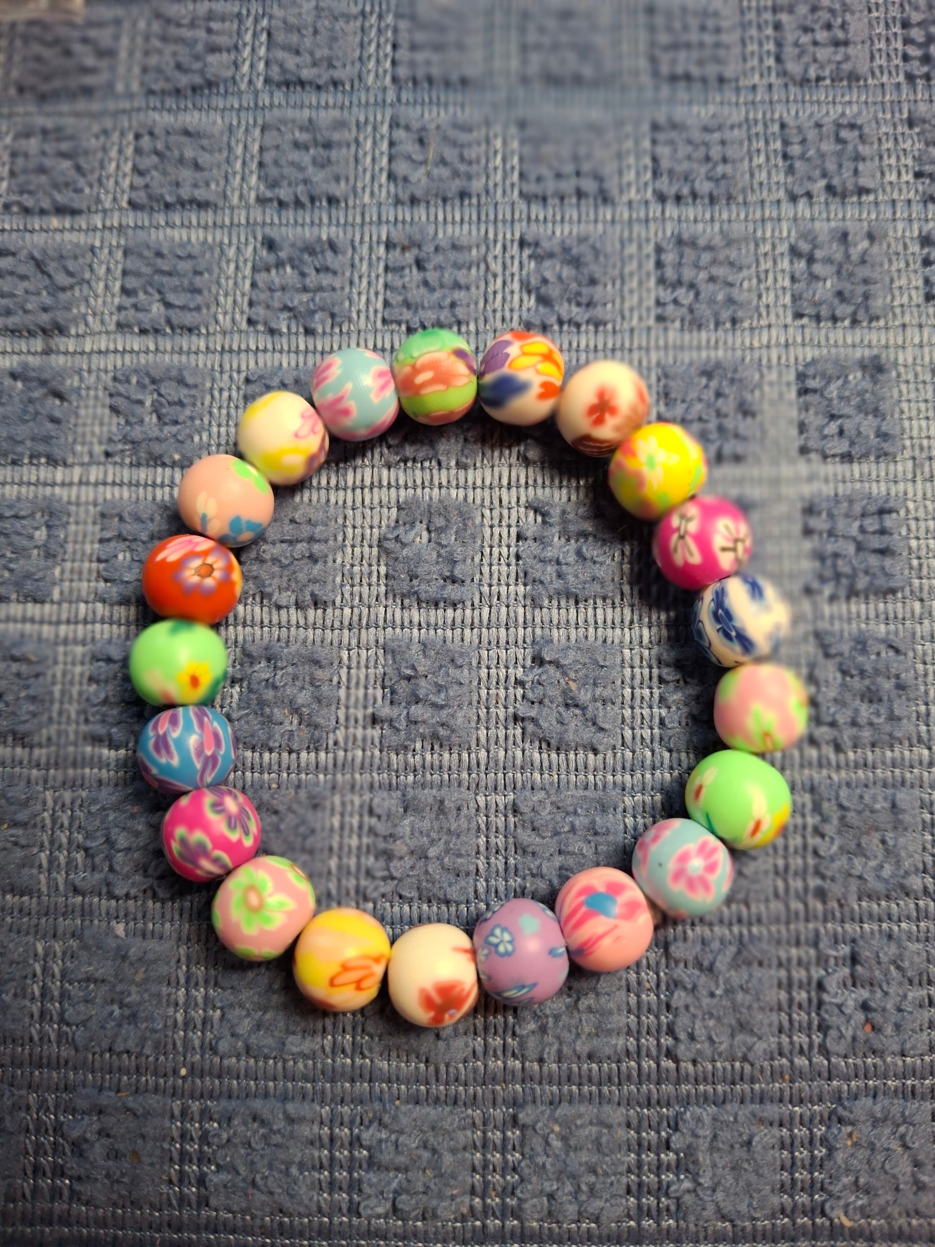 Colorful beaded bracelet on a textured gray surface