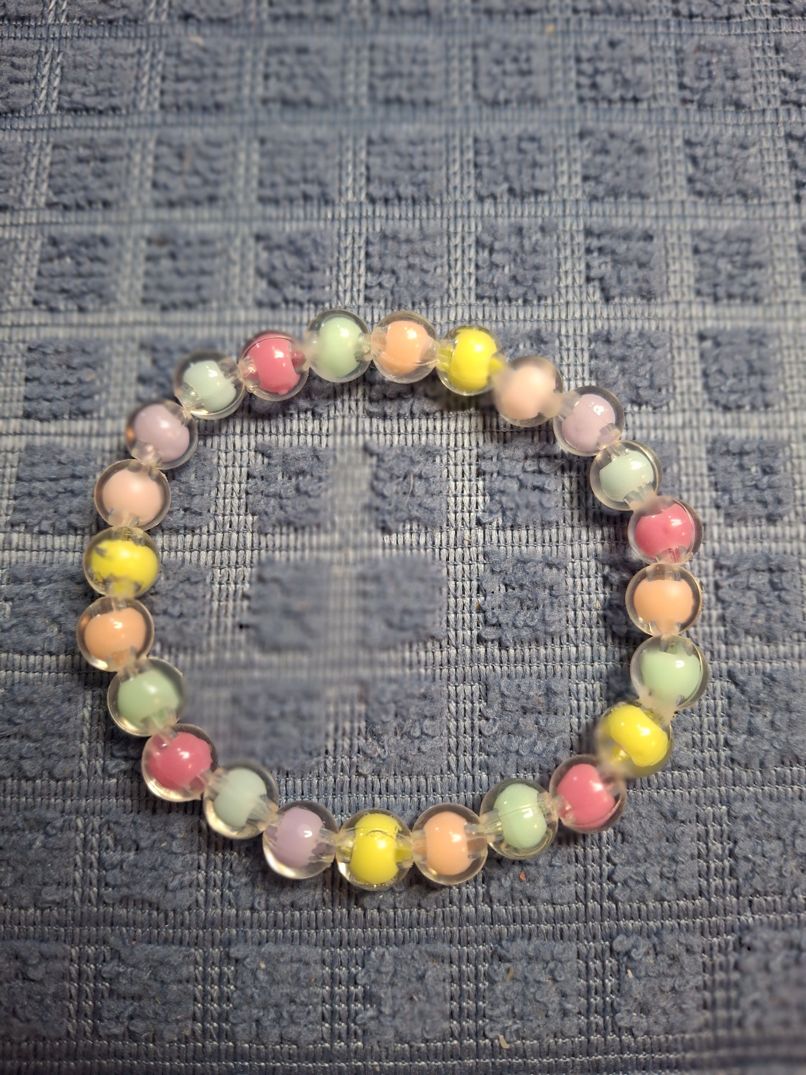 Colorful beaded bracelet on a textured gray surface