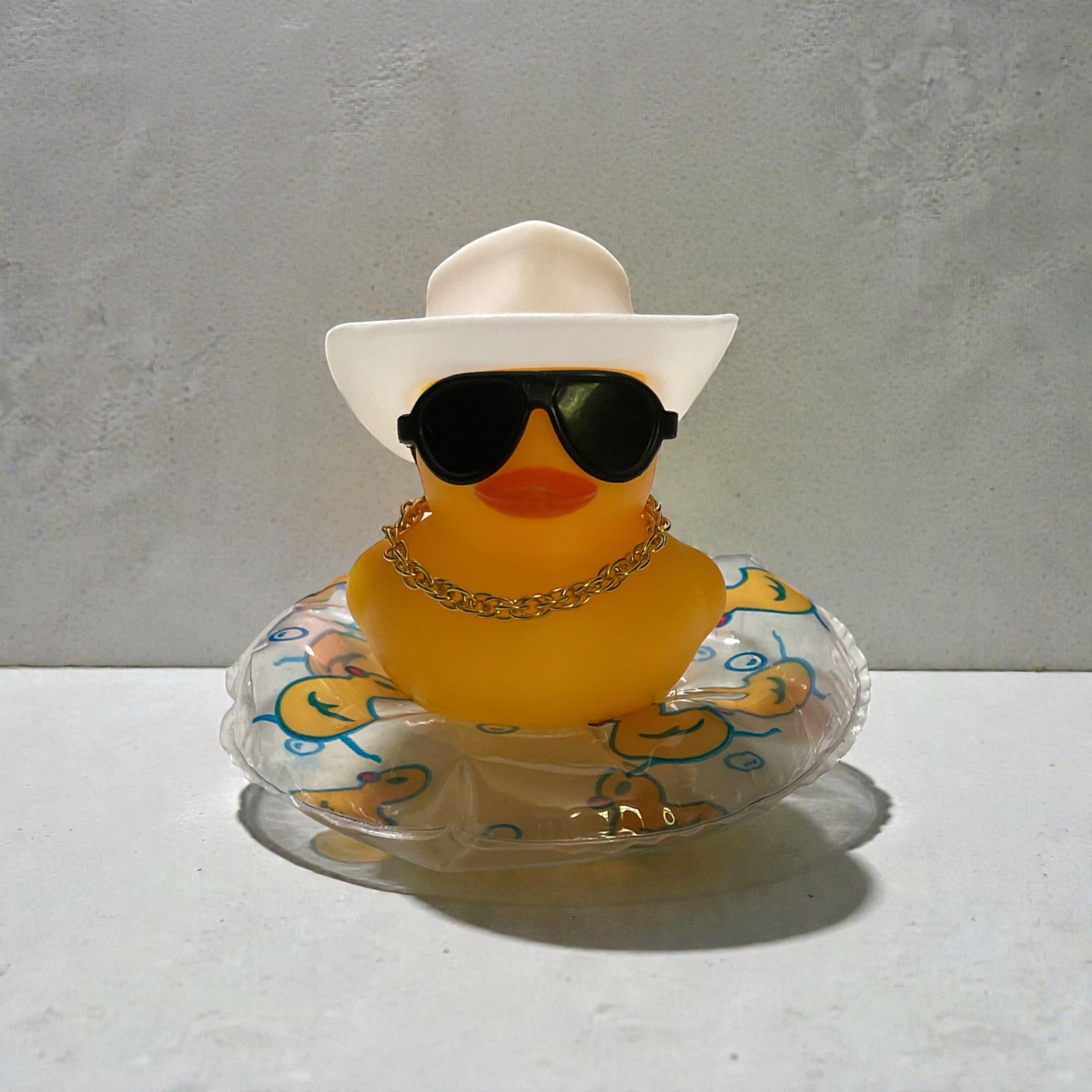 Yellow Duck with White Cowboy Hat, Black Sunglasses, Gold Necklace sitting on a Clear Tube