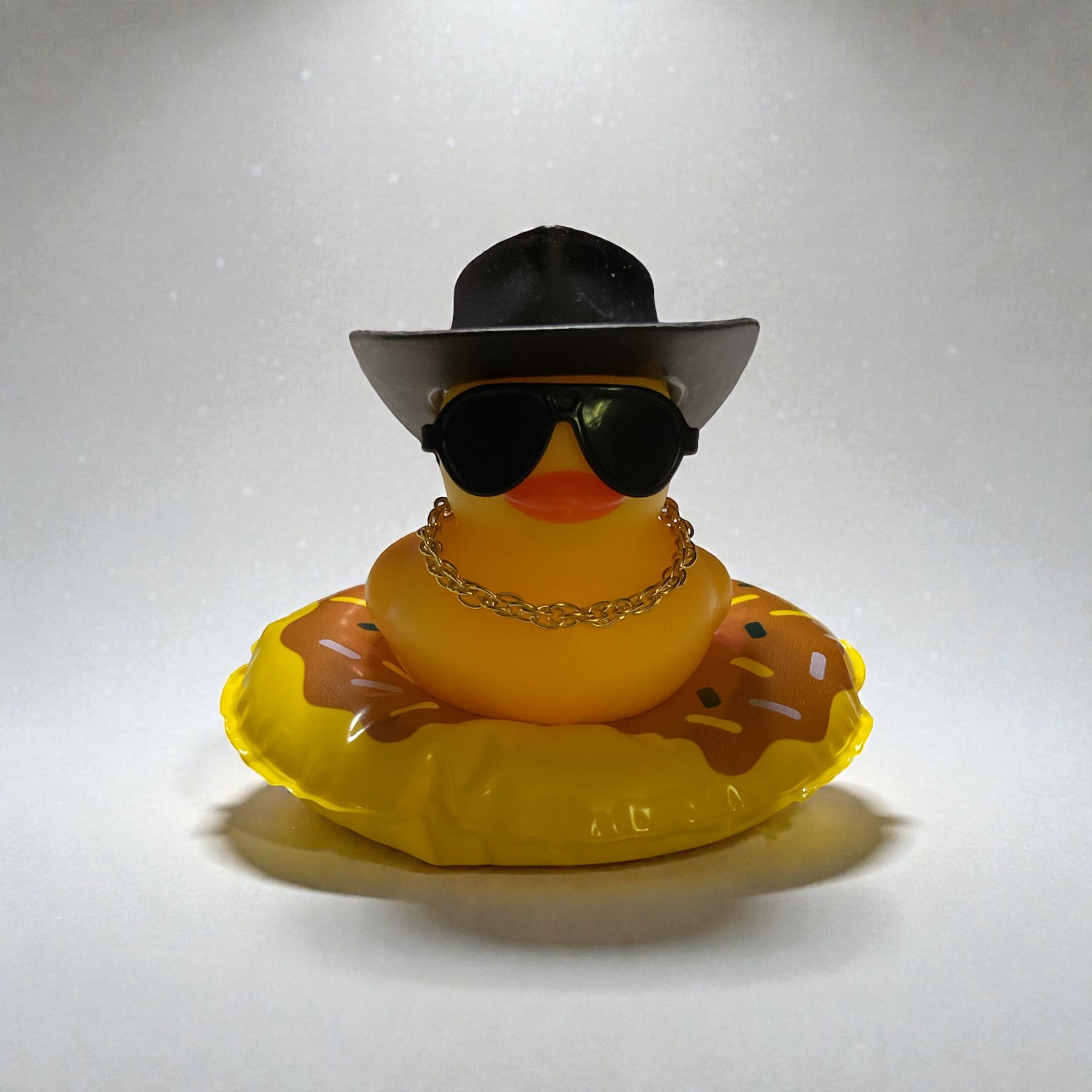 Yellow Duck with Black Cowboy Hat, Black Sunglasses, Gold Necklace sitting on a Donut Tube