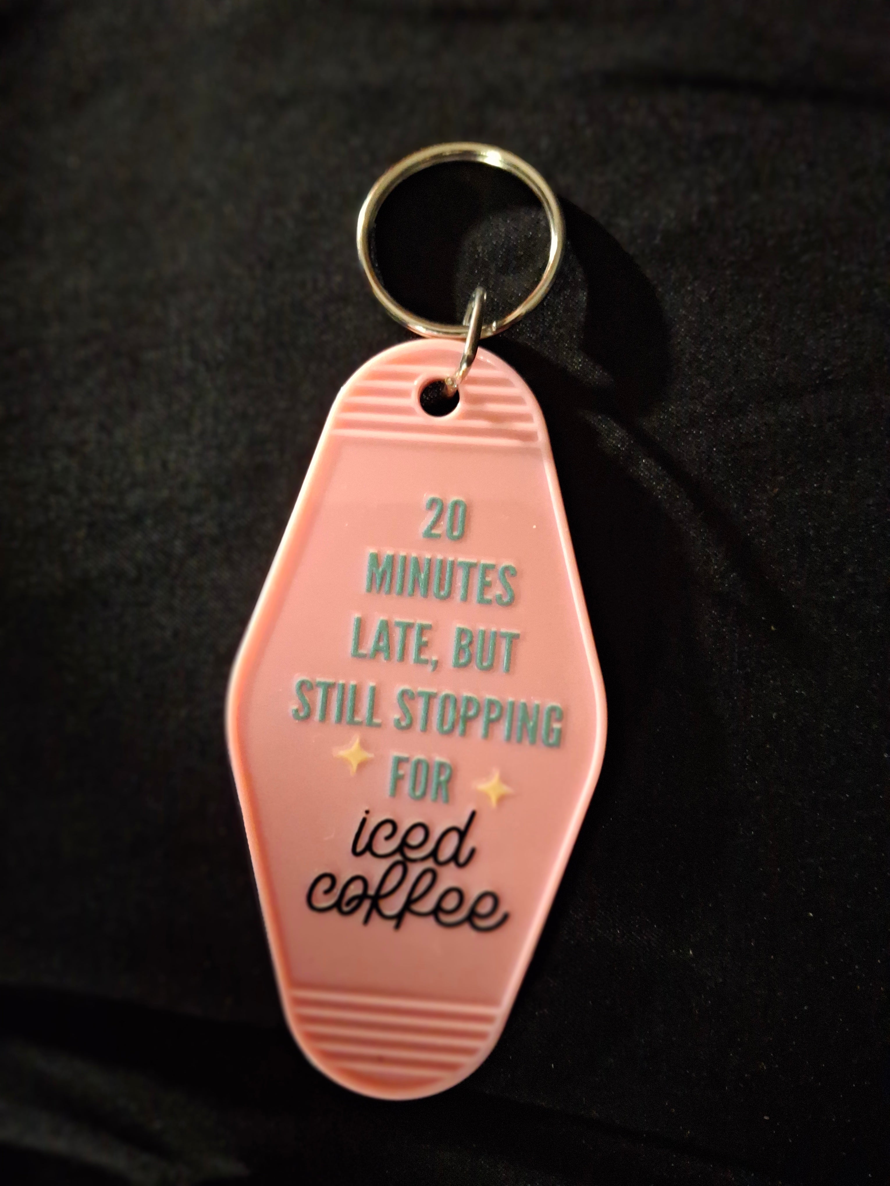 Pink keychain tag with text on a black background