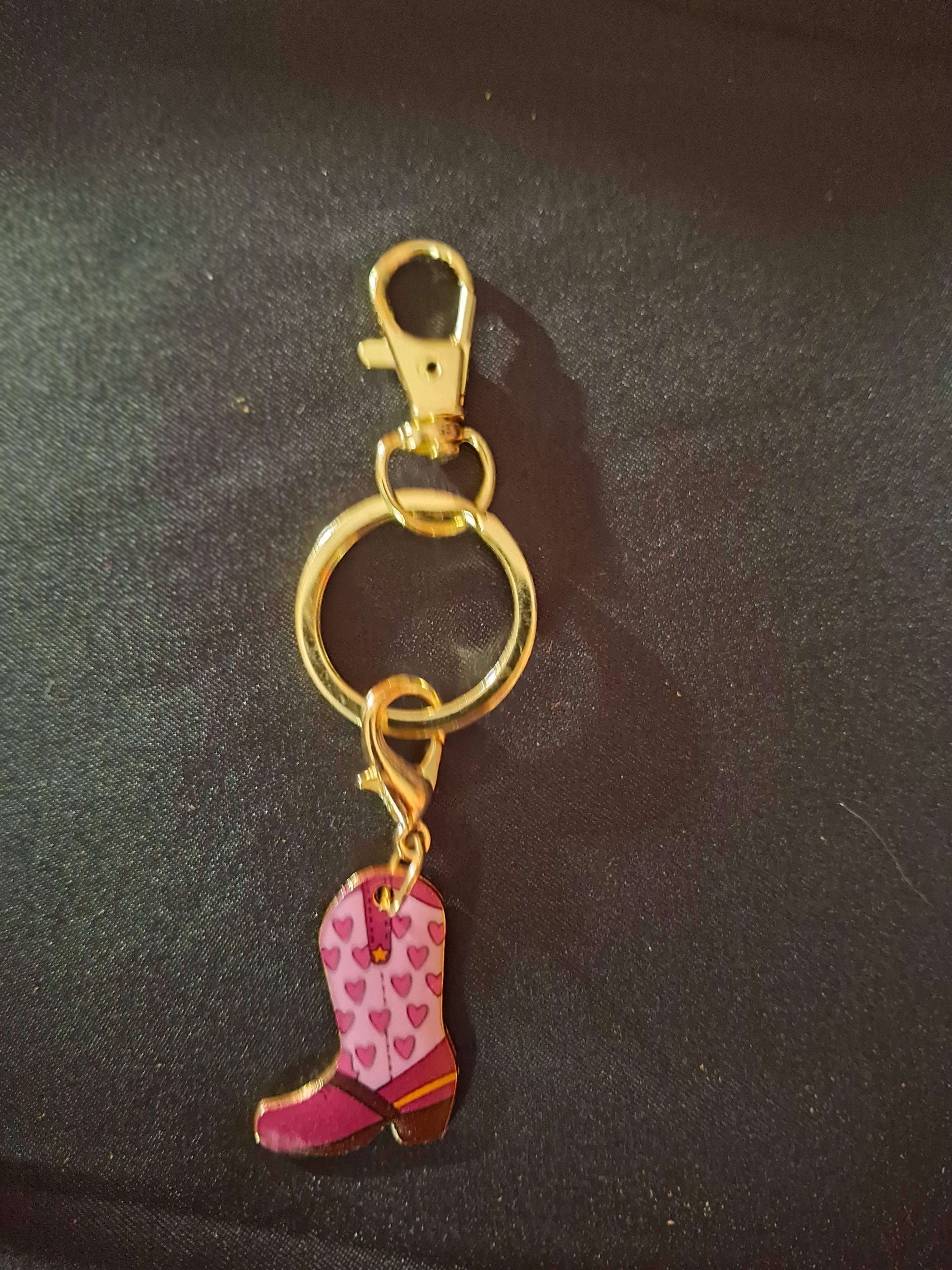 Keychain with pink shoe charm on a dark background
