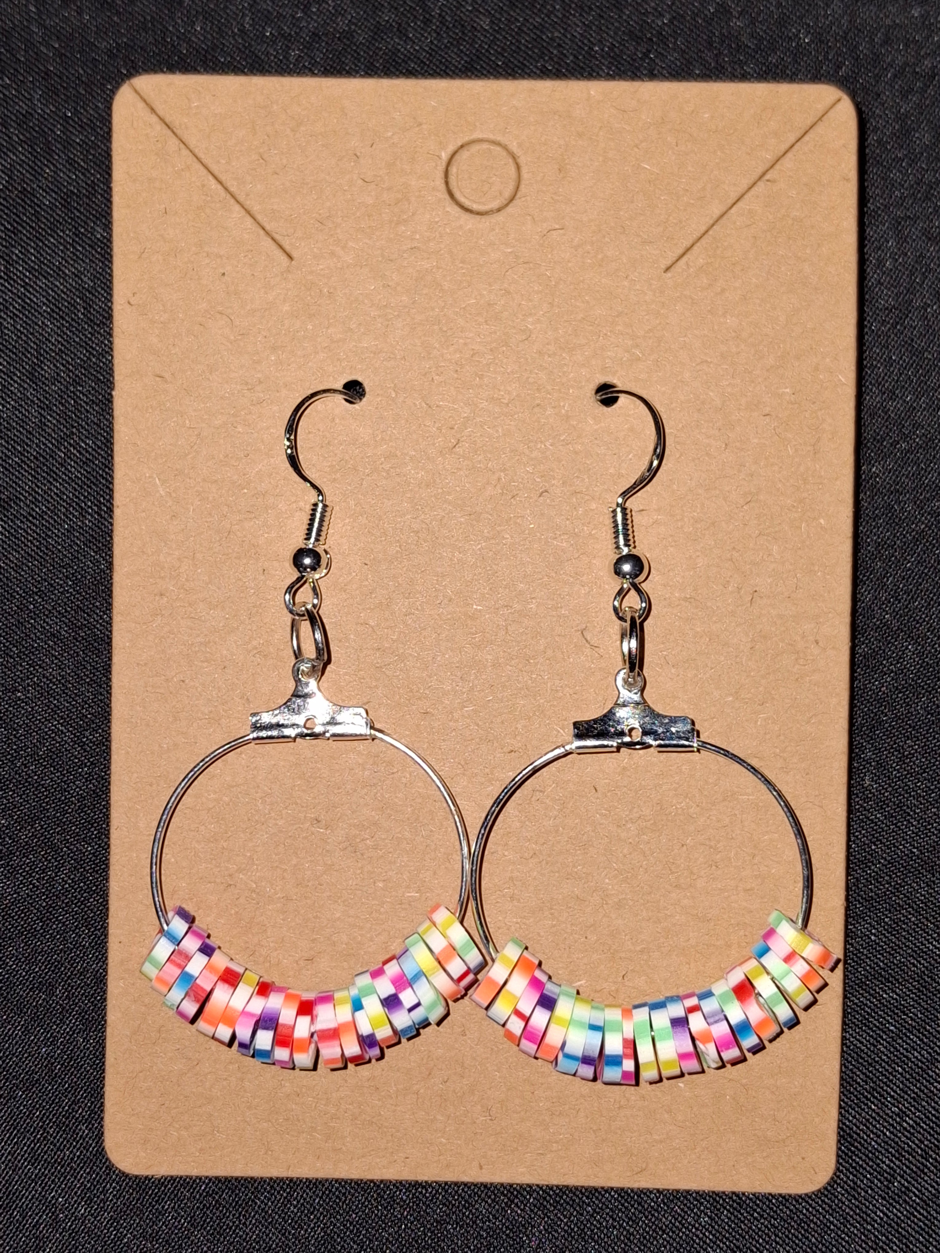 Colorful beaded hoop earrings on a cardboard backing