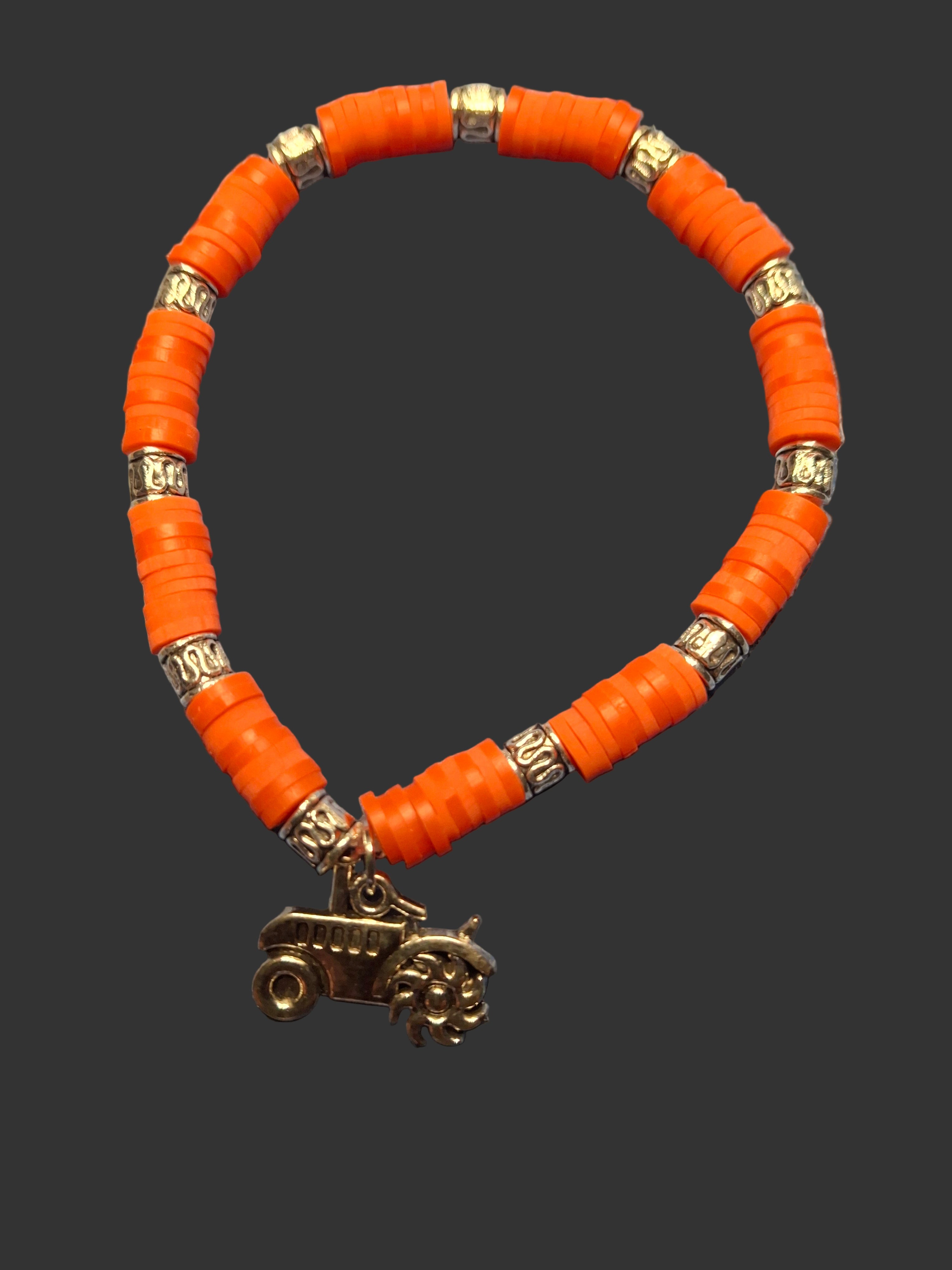 Orange beaded bracelet with gold accents on a textured blue surface