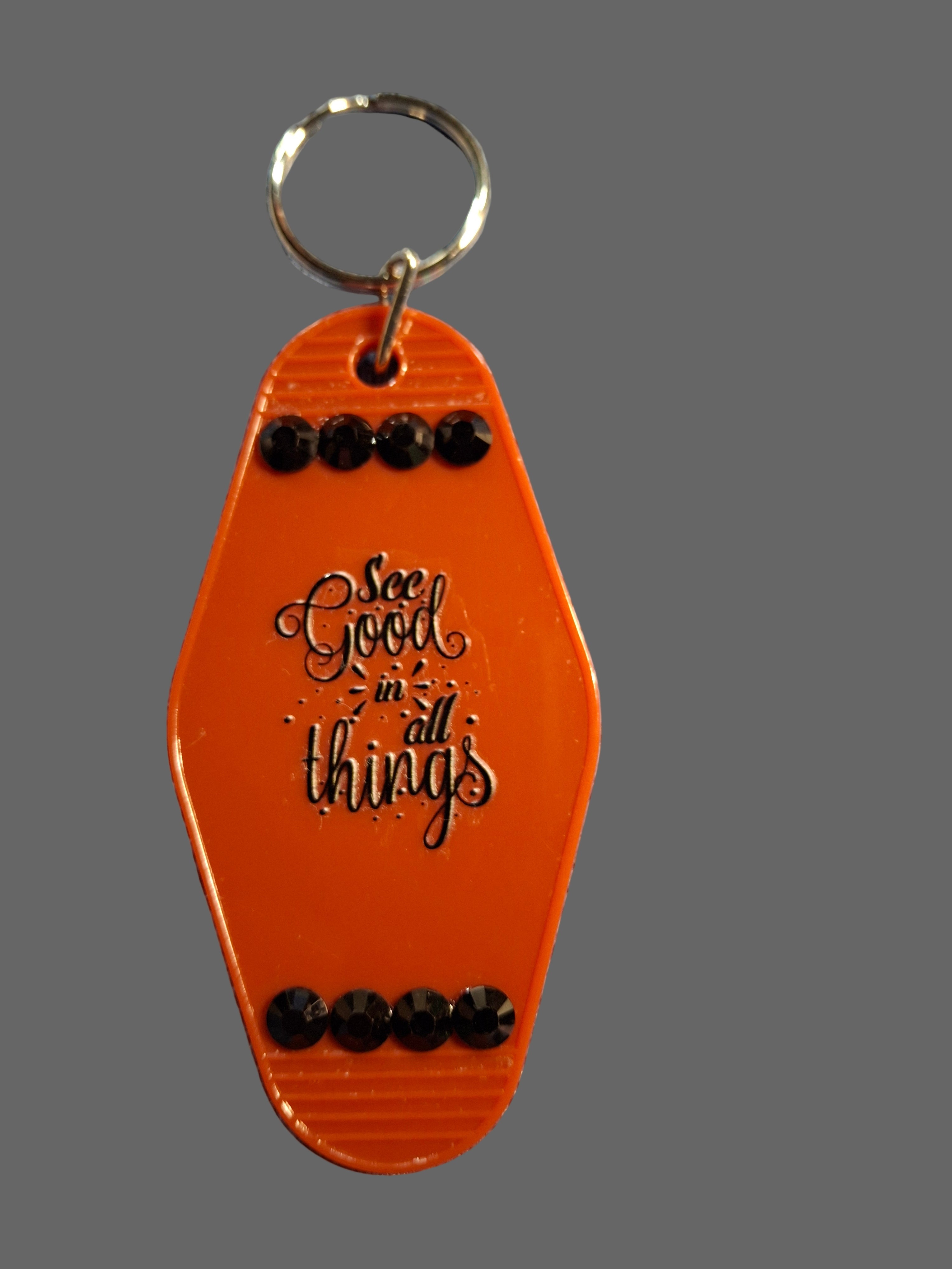 Orange keychain with decorative elements on a textured surface