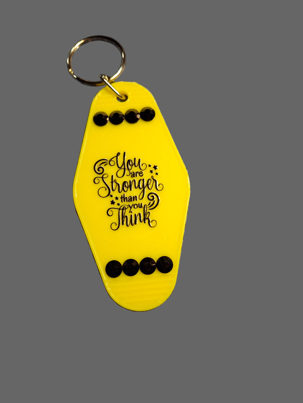 Yellow keychain with motivational quote on a gray background