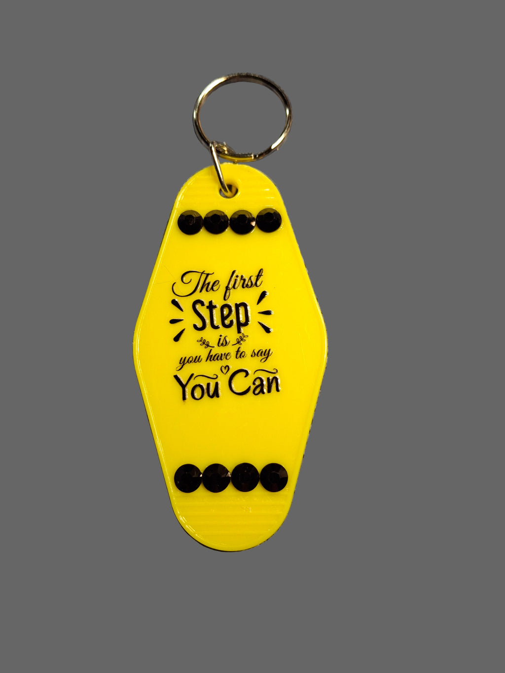 Yellow keychain with motivational quote on a gray background
