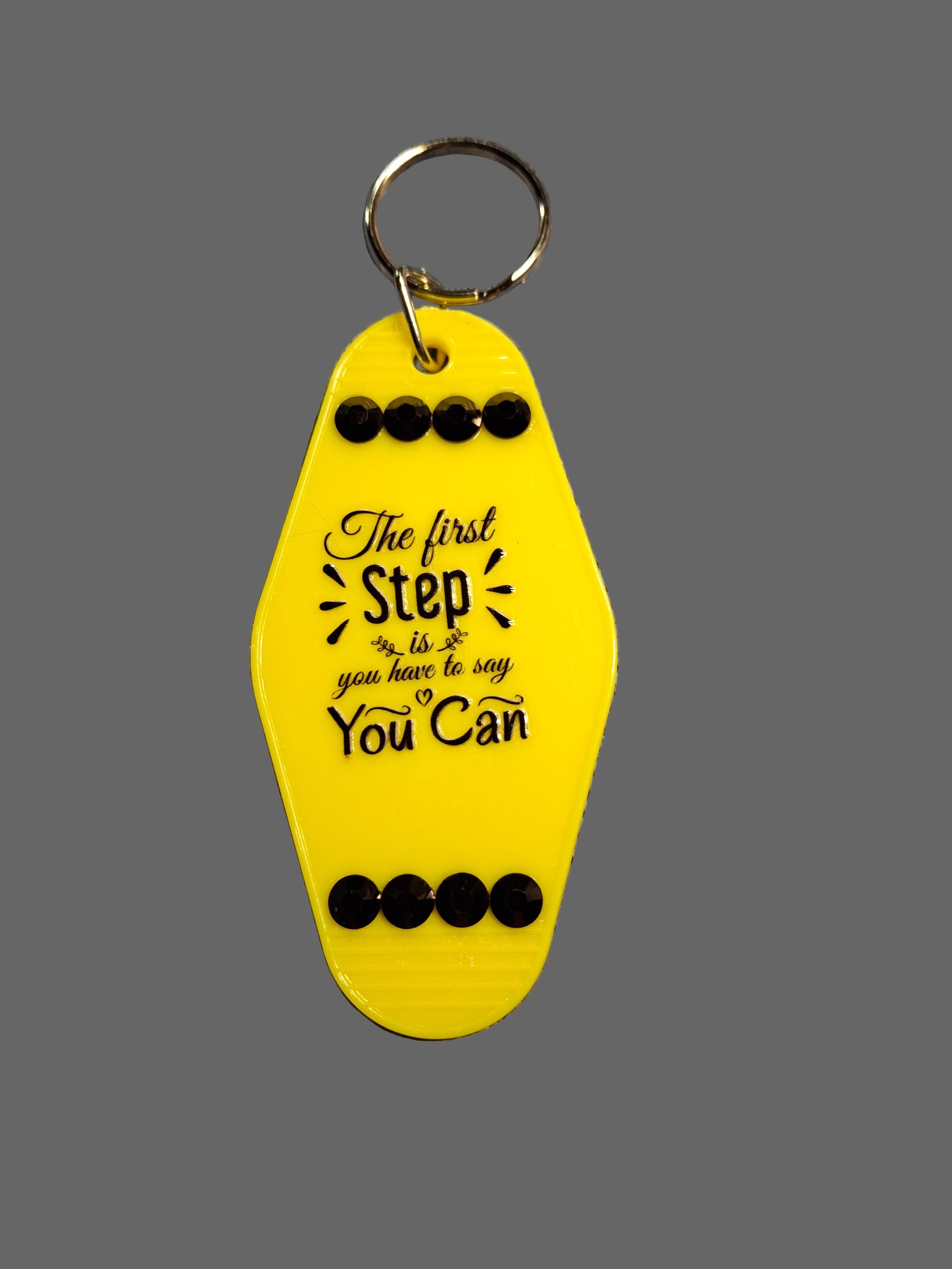 Yellow keychain with motivational quote on a gray background