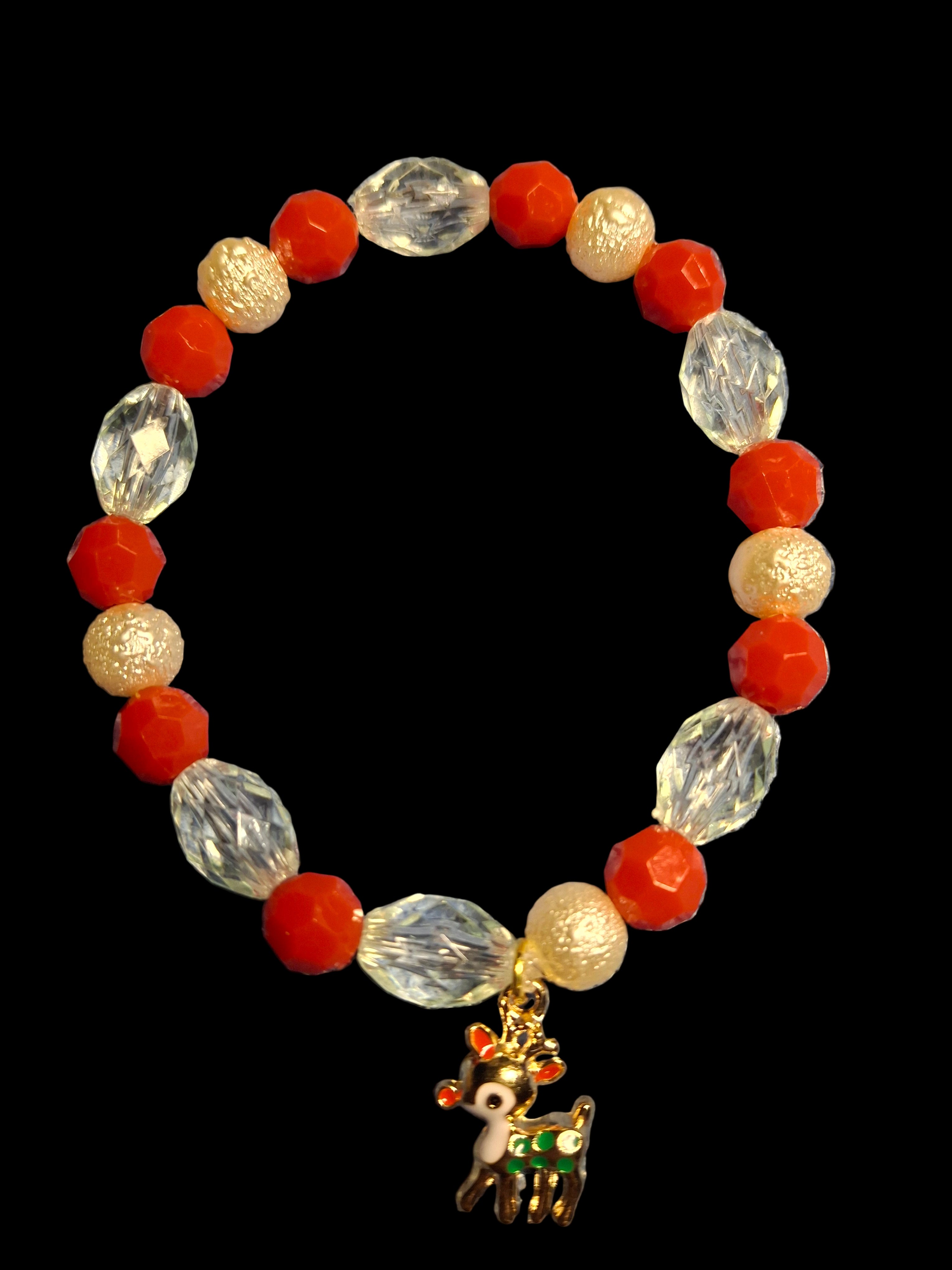 Bracelet with red, white, and gold beads and a reindeer charm on a black background