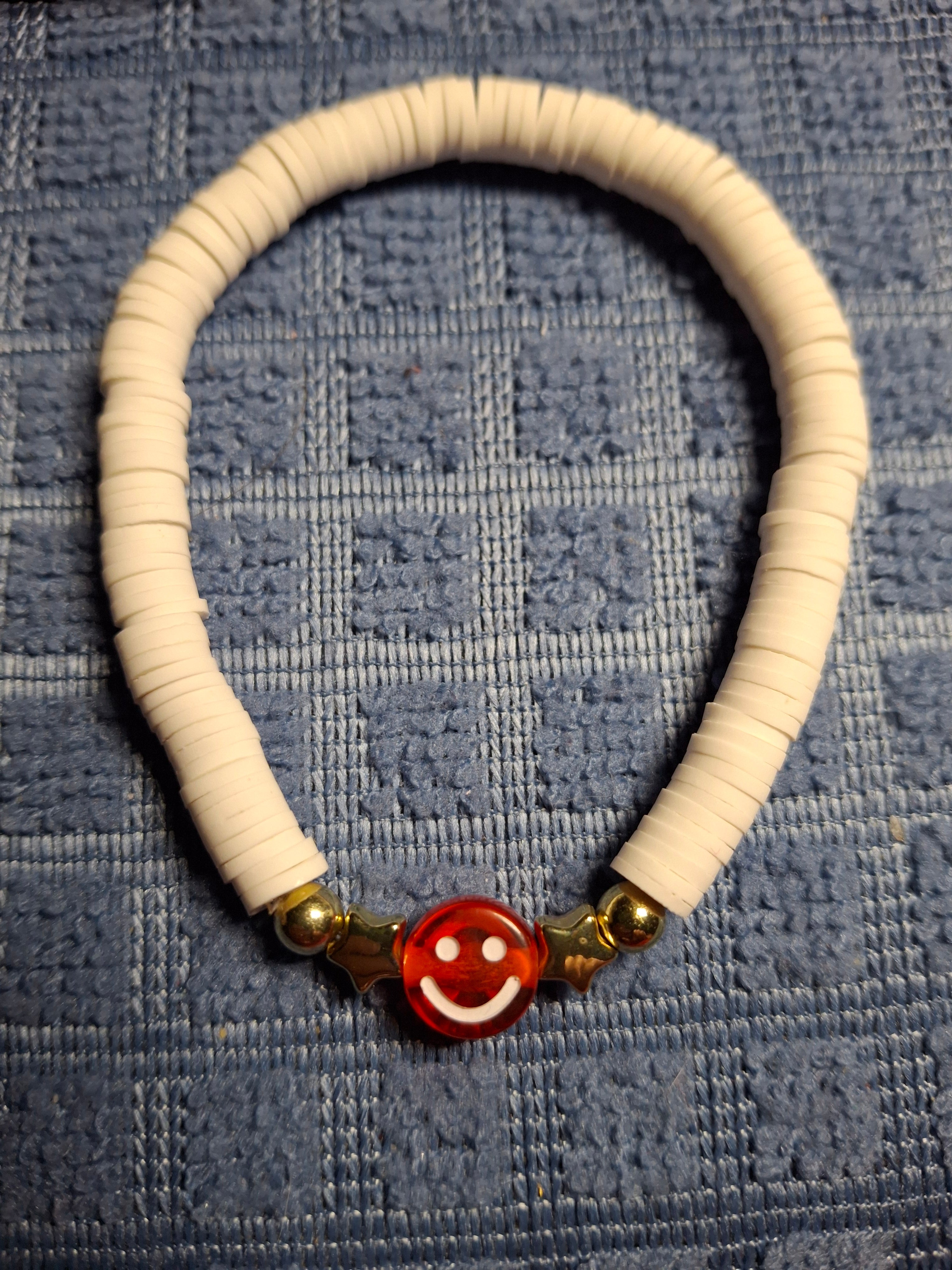 White clay beads with red smiley face