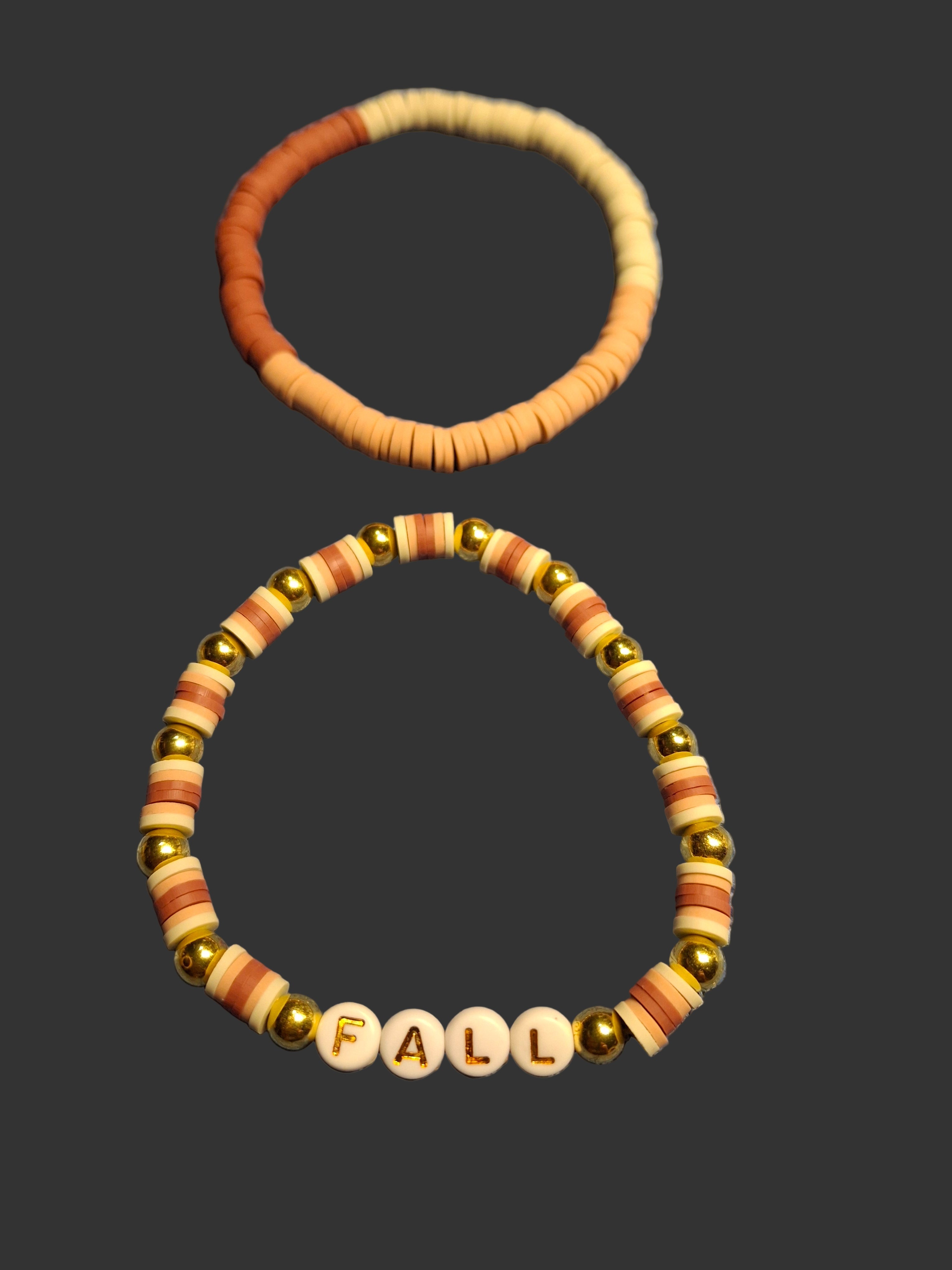 Two beaded bracelets on a dark background, one plain and one with 'FALL' beads.