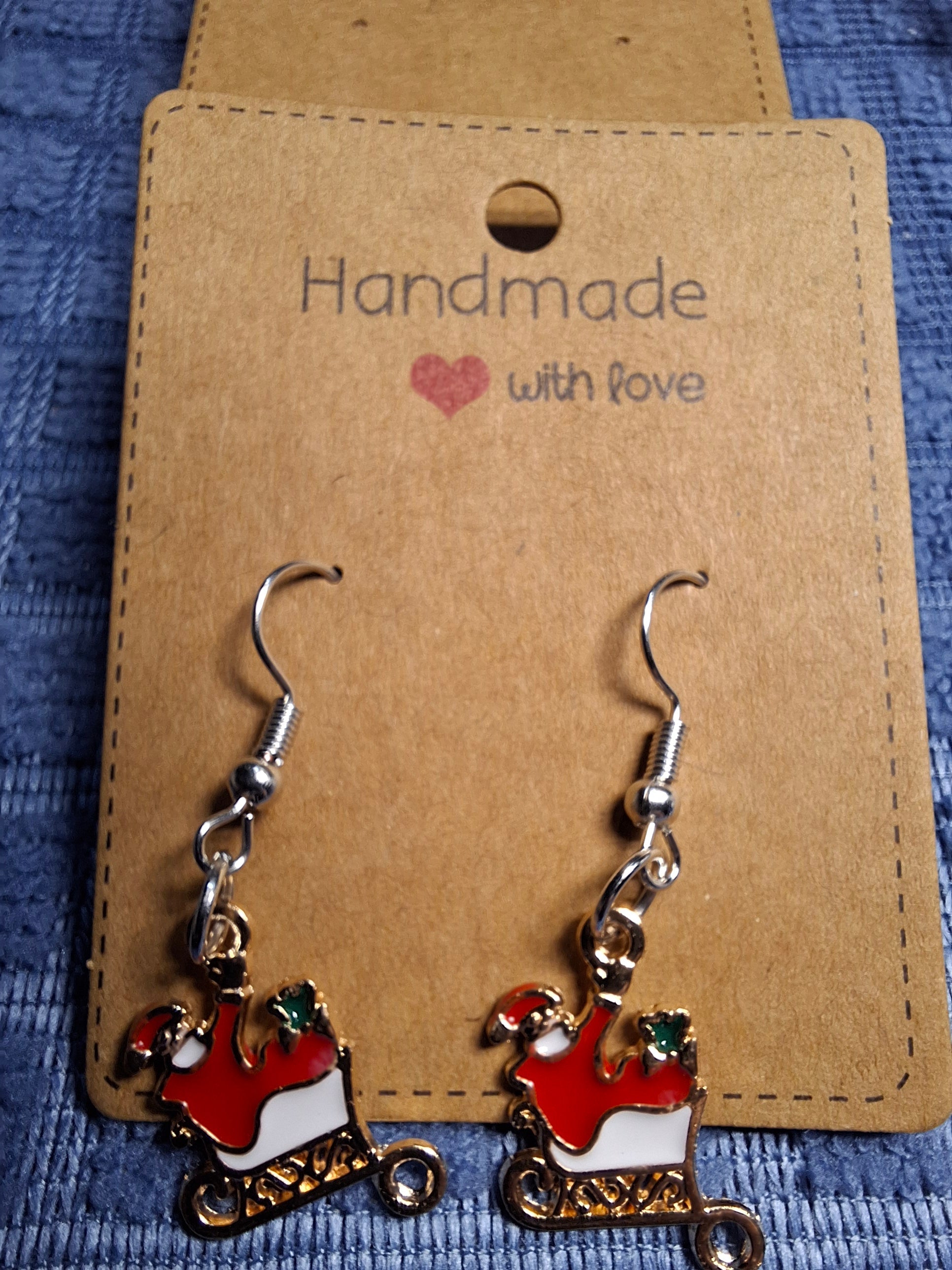 Handmade earrings with a Santa Claus design on a brown card with 'Handmade with love' text.